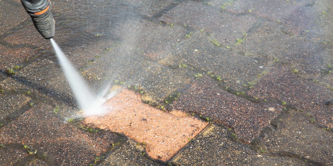 Image of a pressurewasher washing a brick patio