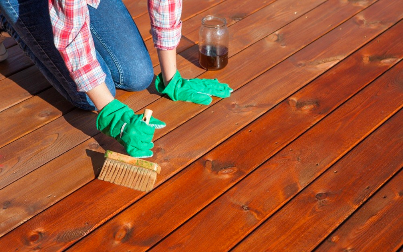 Image of a homeowner sweeping their outdoor deck and patio.