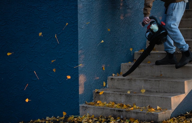 Image of a person blowing leaves away from a staircase